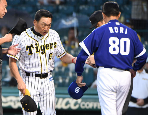 メンバー表を交換する金本知憲監督（左）と森繁和監督（撮影・奥田泰也）