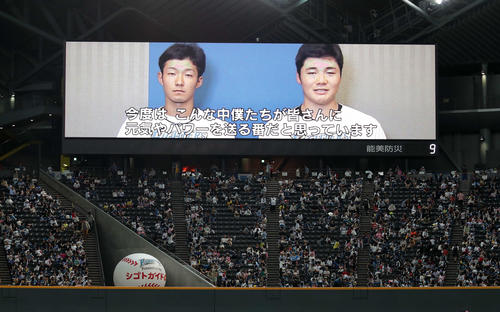 大型ビジョンに流れる、日本ハム石井一（左）と清宮の被災者へのメッセージ（撮影・佐藤翔太）