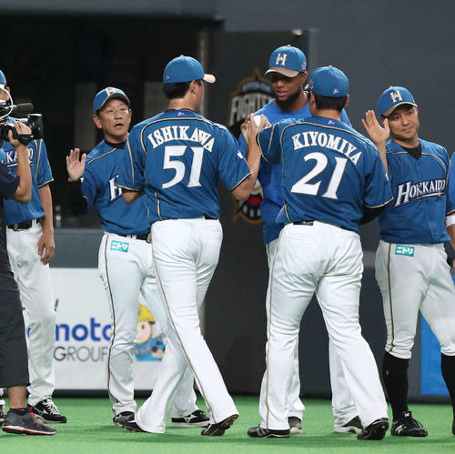 試合後、ナインを出迎える栗山監督（左）（撮影・黒川智章）