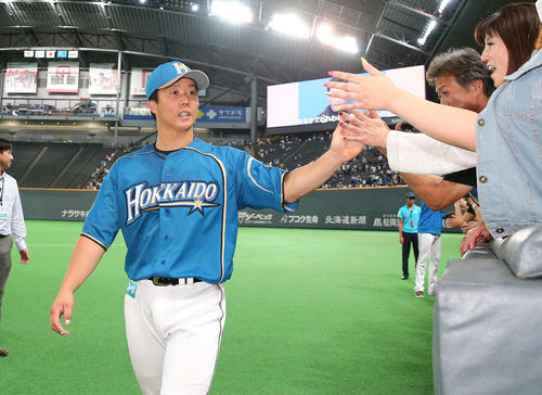 試合後、ファンとハイタッチする鶴岡（撮影・黒川智章）