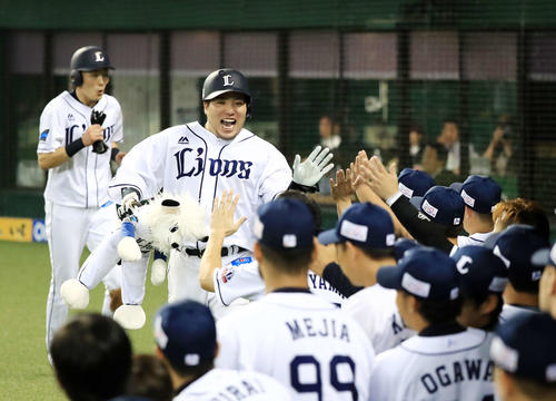 西武対ソフトバンク　8回裏西武2死二塁、40号となる2点本塁打を放ち笑顔でナインとタッチをかわす山川。左端は源田（撮影・江口和貴）