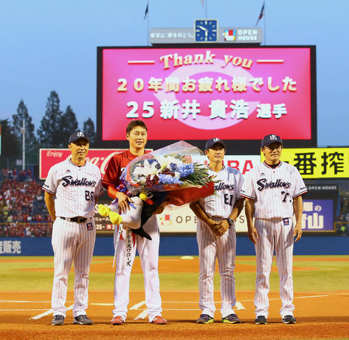 今季での引退を発表ている広島新井(左から2人目)は試合前、ヤクルト宮本ヘッドコーチ(左端)、石井コーチ(同3人目)、河田コーチからの花束に笑顔を見せる(撮影・足立雅史)