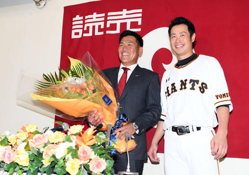引退会見で亀井（右）から花束を贈られ笑顔を見せる巨人脇谷（撮影・たえ見朱実）