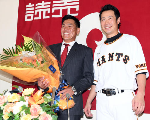 引退会見で亀井（右）から花束を贈られ笑顔を見せる脇谷（撮影・たえ見朱実）