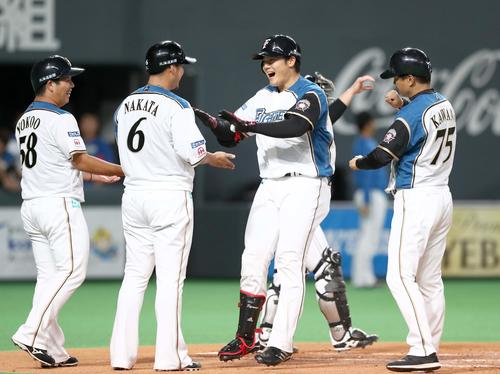 1回裏日本ハム2死一、二塁、右越え3点本塁打を放った清宮は中田（左から2人目）に出迎えられ笑顔を見せる（撮影・黒川智章）
