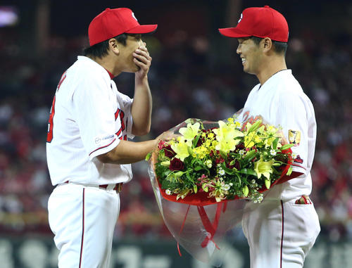 小窪哲也（右）から花束を受け取る天谷宗一郎（撮影・栗木一考）
