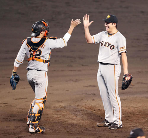 阪神対巨人　最後を締めた菅野（右）は小林と笑顔でハイタッチ（撮影・前田充）