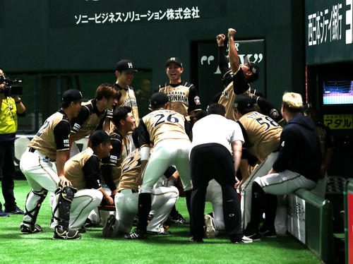 試合前、ベンチ前で円陣を組む日本ハムナイン（撮影・佐藤翔太）