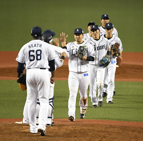 西武対ソフトバンク　ソフトバンクに勝利しハイタッチする浅村（中央）、源田（同右）ら西武ナイン（撮影・鈴木みどり）