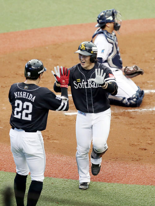 西武対ソフトバンク　2回表ソフトバンク2死一塁、2点本塁打を放ち、西田（左）とタッチを交わす甲斐（撮影・狩俣裕三）