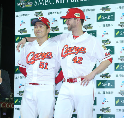 お立ち台で鈴木誠也を頼もしそうに見るジョンソン（撮影・梅根麻紀）