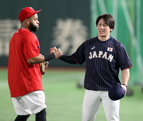 練習中、談笑をするサンタナ（左）と甲斐（撮影・狩俣裕三）