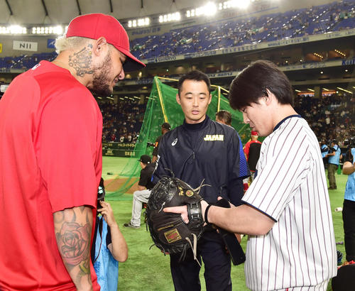 試合前、モリーナ（左）のキャッチャーミットを貸してもらい感触を確かめる甲斐（撮影・清水貴仁）