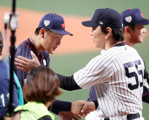 MLB対日本　試合後、岡本（左）と握手を交わす松井コーチ（撮影・狩俣裕三）