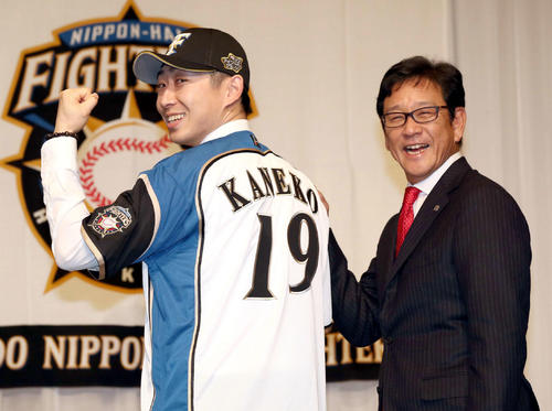 日本ハムの入団会見で背番号19を披露する金子。右は栗山監督（撮影・黒川智章）