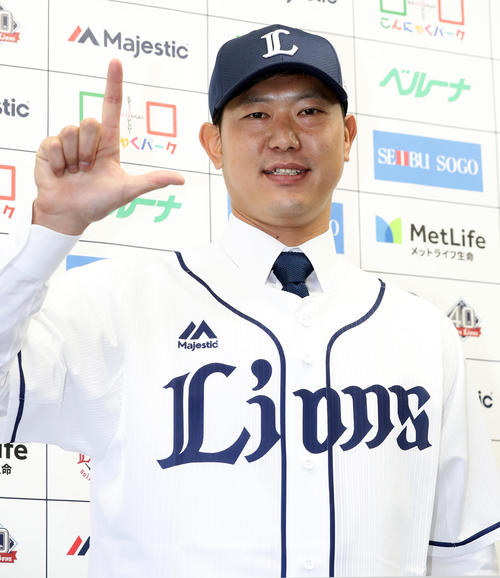西武入団会見でユニホームを着用し笑顔で「L」ポーズをとる内海（撮影・浅見桂子）