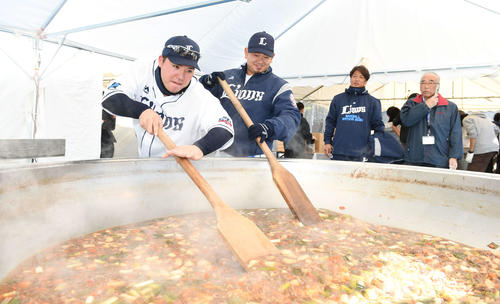ファン感謝デーで、真剣な表情で大鍋をかき回す西武山川（左）と森（撮影・鈴木みどり）
