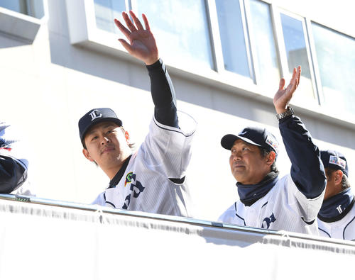 優勝パレードで沿道のファンに手を振る西武浅村（左）（撮影・鈴木みどり）