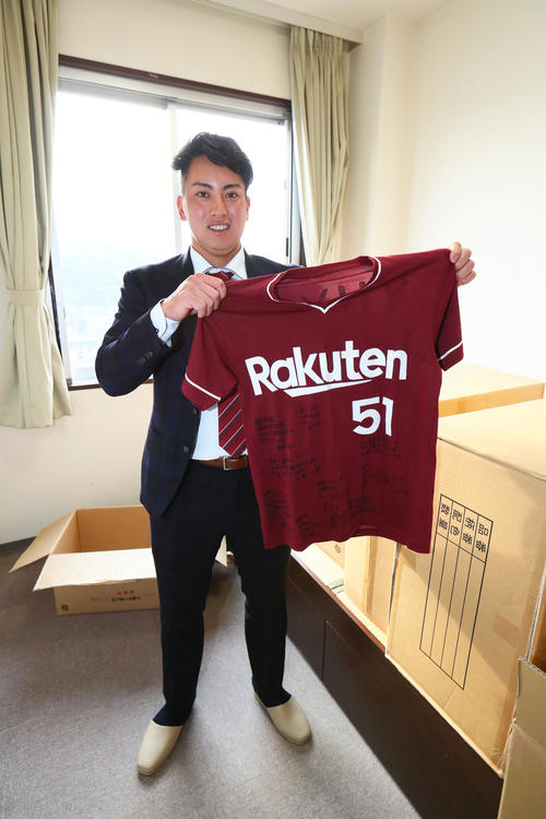 楽天ドラフト4位小郷は友人らからのメッセージ入りユニホームを手に笑顔を見せる(撮影・足立雅史)