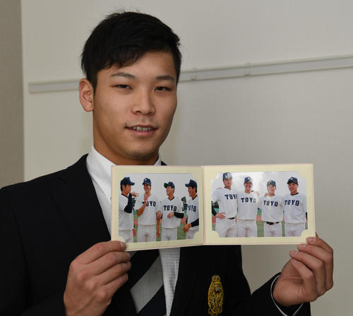 ドラフトで指名された東洋大4選手の写真を手にするオリックス中川圭太(撮影・渦原淳)