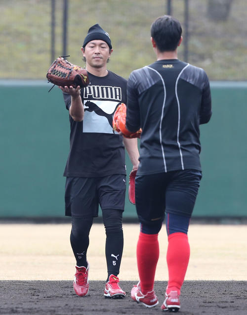 練習を終えた広島堂林翔太にグラブを手渡す優しい長野久義=日南(撮影・梅根麻紀)