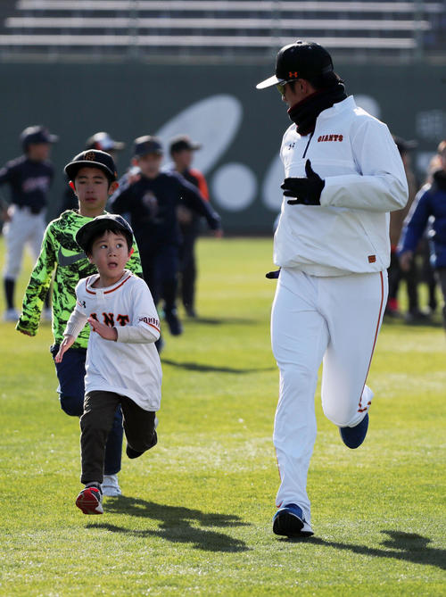 選手たちと並んでウオーミングアップする子どもと併走しておどける巨人陽（右）（撮影・垰建太）