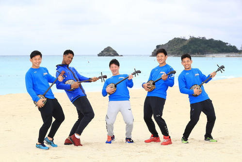 キャンプ休日に三線を体験しビーチで記念撮影する吉田輝（中央）ら日本ハムの新人選手。左から柿木、万波、1人おいて野村、田宮（撮影・江口和貴）
