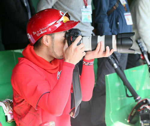 カメラを構える菊池涼介（撮影・栗木一考）