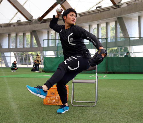 座った状態から投球練習する坂本工(撮影・垰建太)