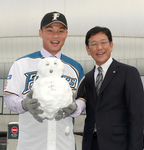 入団会見で札幌ドームを背に雪だるまと共に笑顔で撮影に応じる日本ハム王柏融（左）と栗山監督