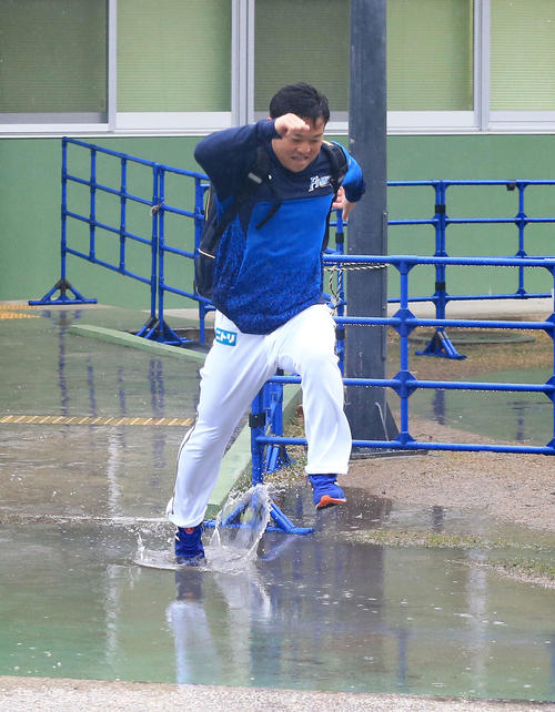 クラブハウスから出た日本ハム生田目は水たまりをジャンプする(撮影・江口和貴)