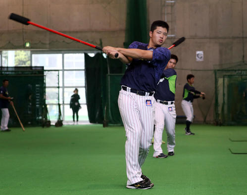 トレーニング用の長いバットで素振りする村上(撮影・狩俣裕三)