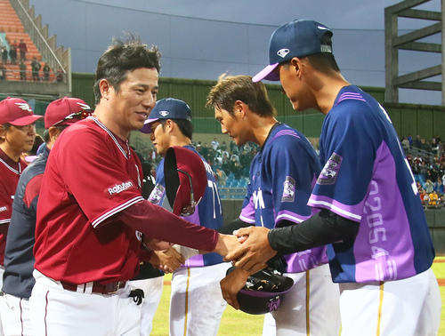 台湾遠征を終え、ラミゴナインと握手を交わす楽天平石洋介監督(左)(撮影・足立雅史)
