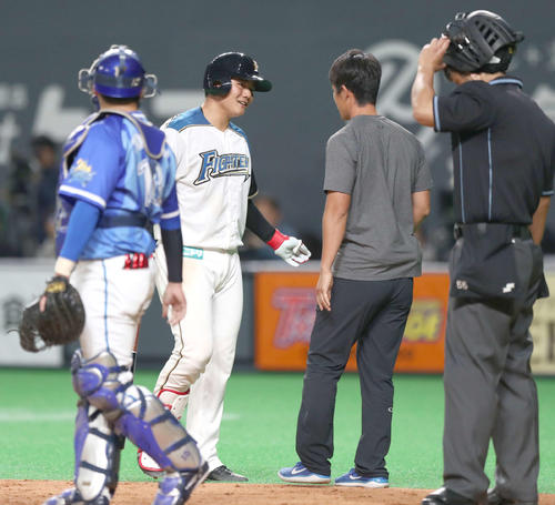 日本ハム対DeNA　9回裏日本ハム1死、2球目をファウルチップしたあとトレーナーと話し途中交代する清宮（撮影・黒川智章）