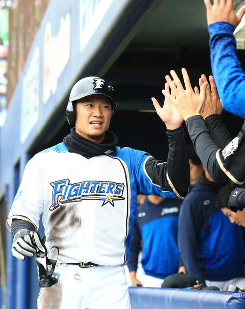 日本ハム対ロッテ　3回裏日本ハム無死一塁、近藤の適時二塁打で生還しナインとタッチをかわす西川（撮影・江口和貴）