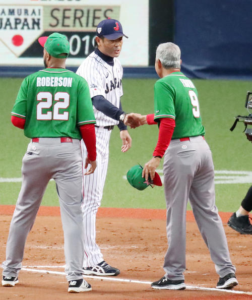 試合後、フィロバ監督（右）と握手する稲葉監督（撮影・加藤哉）