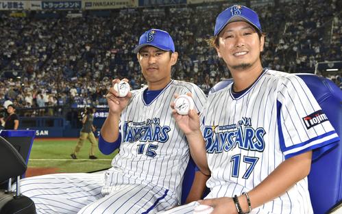 18年8月22日の巨人戦。ヒーローインタビュー後、場内1周する車でサインボールを手にポーズを決めるＤｅＮＡ三嶋（右）と井納