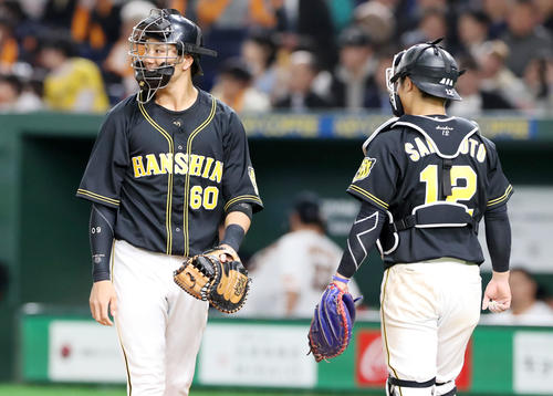 巨人対阪神　5回裏を前に坂本が準備している間、中谷（左）が防具を着けてマスクを被りボールを受けた（撮影・加藤哉）