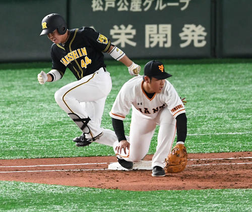 2日の巨人－阪神戦、2回に三塁内野安打で一塁を駆け抜ける阪神梅野（左）。一塁手岡本（撮影・山崎安昭）