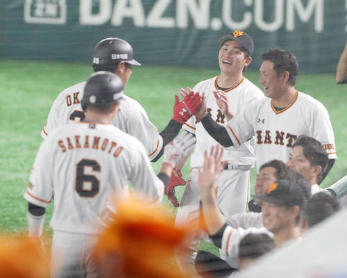 巨人対阪神　1回裏巨人2死一塁、高橋（中央）は岡本の中越え2点本塁打を笑顔で出迎える（撮影・加藤哉）