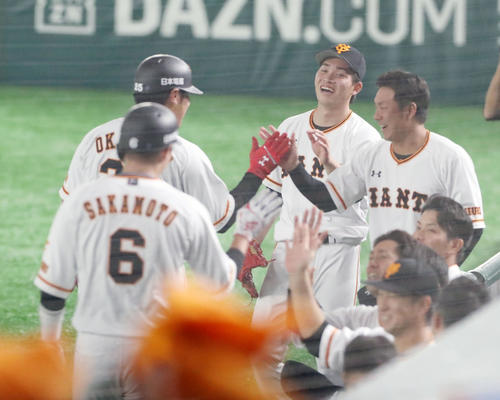 巨人対阪神 1回裏巨人2死一塁、高橋(中央)は岡本の中越え2点本塁打を笑顔で出迎える(撮影・加藤哉)
