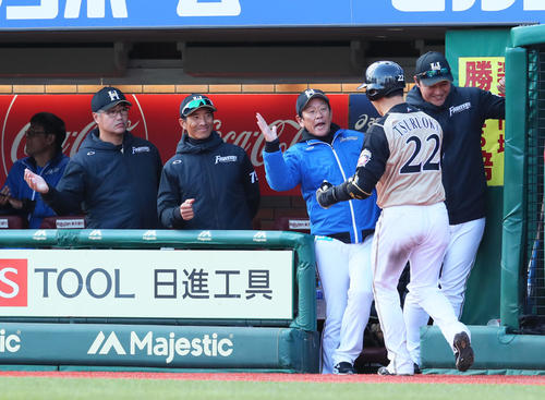 楽天対日本ハム　6回表日本ハム1死、左越え本塁打を放った鶴岡（右から2人目）をタッチで迎える栗山監督（同3人目）らナイン（撮影・足立雅史）