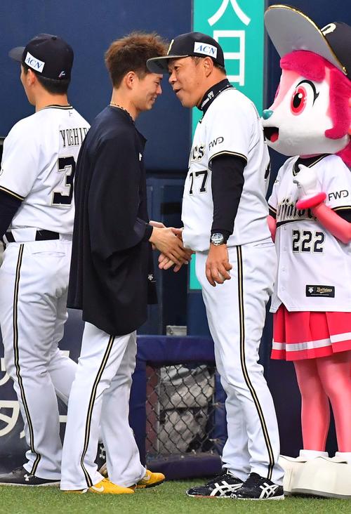 1勝目をあげ山岡泰輔（左）から勝利球を受け取り笑顔で握手を交わす西村徳文監督（撮影・上田博志）