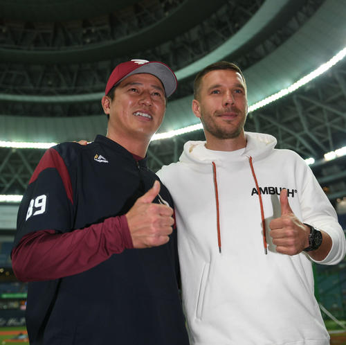 試合前、球場を背に記念写真に納まる神戸FWポドルスキ（右）と楽天平石洋介監督（撮影・渦原淳）