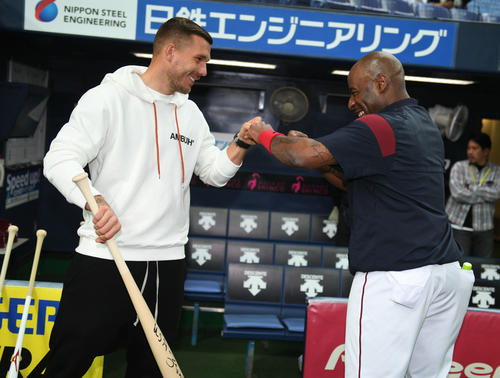 試合前、楽天ゼラス・ウィーラー（右）からサイン入りバットをプレゼントされる神戸FWポドルスキ（撮影・渦原淳）