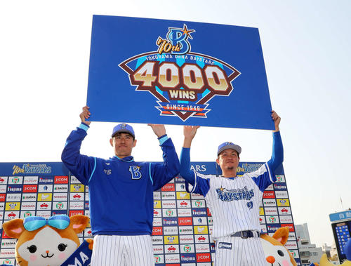 DeNA対巨人　通算4000勝のボードを手に写真に納まるDeNA井納翔一（左）と大和（撮影・鈴木正人）