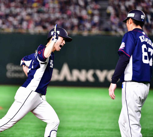 日本ハム対西武　8回表西武1死一、三塁、外崎は左越えに逆転3点本塁打を放ち黒田三塁コーチ（右）の祝福を受ける（撮影・小沢裕）