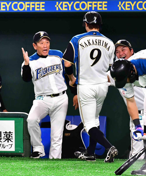 日本ハム対西武　3回裏日本ハム1死三塁、西川の右前適時打で生還した中島（右）は栗山監督の祝福を受ける（撮影・小沢裕）