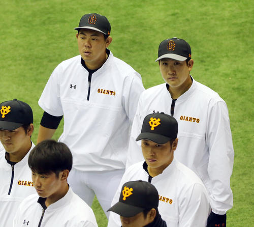 練習前、ミーティングでコーチの話を聞く巨人山口（左）と菅野（撮影・垰建太）