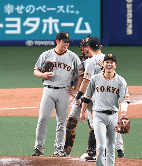 中日対巨人　7回裏中日2死二塁、山口俊（左）はマウンドに来た宮本投手総合コーチ（中央）に声をかけられ笑顔を見せる。右は坂本勇（撮影・山崎安昭）